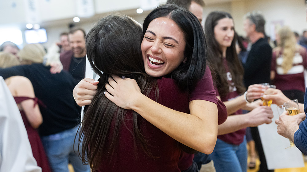 Athena Barrett shares a joyful hug with a classmate at Match Day celebration